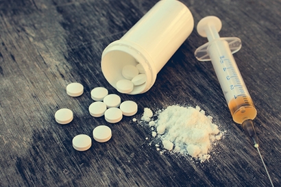 a bottle of pills spilled on the table - drug charges